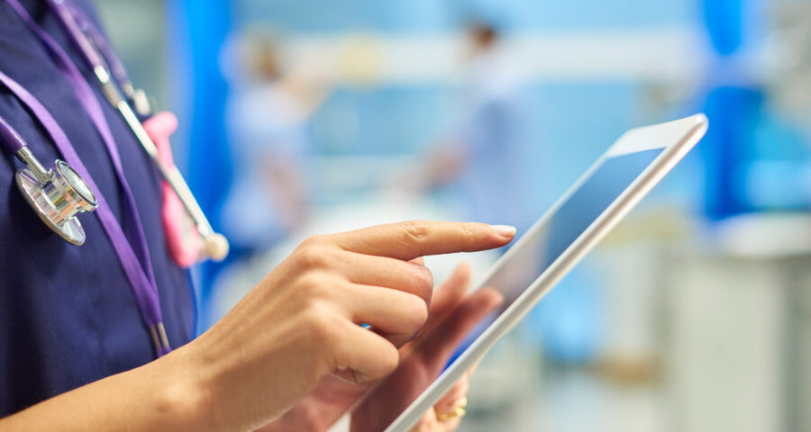 Photograph showing a nurse holding a tablet